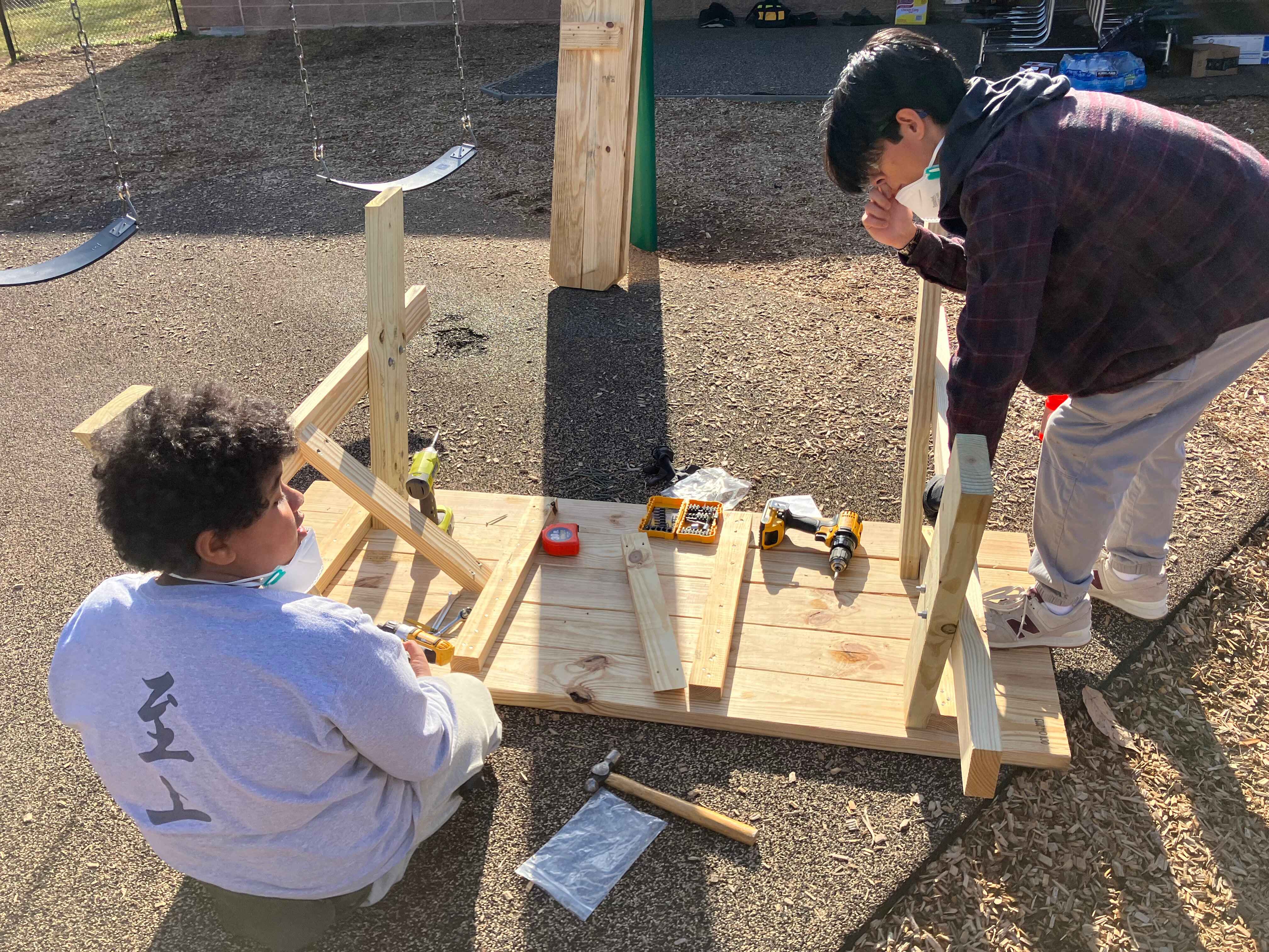 Two volunteers attatching legs to a table